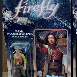 May include: A plastic action figure of Zoe Washburne from the TV show Firefly. The figure is packaged in a blister pack with a photo of Zoe holding a gun. The packaging is blue and black with the words "Firefly" and "ReAction" printed on it.