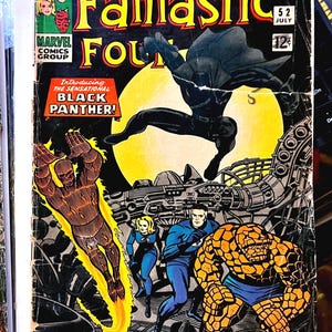 May include: Vintage comic book cover of Fantastic Four #52, featuring Black Panther. The cover art showcases several characters in action, with vibrant colors and dynamic poses. The comic is from July and costs 12 cents.