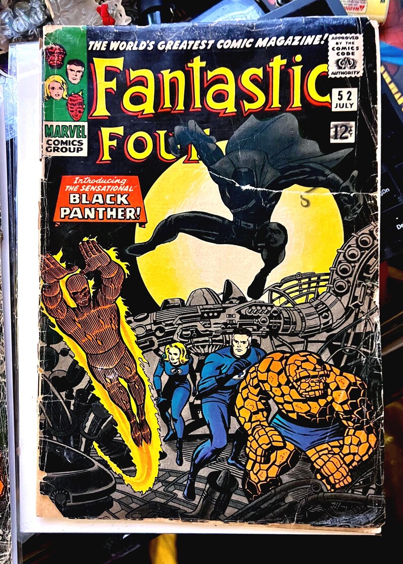 May include: Vintage comic book cover of Fantastic Four #52, featuring Black Panther. The cover art showcases several characters in action, with vibrant colors and dynamic poses. The comic is from July and costs 12 cents.