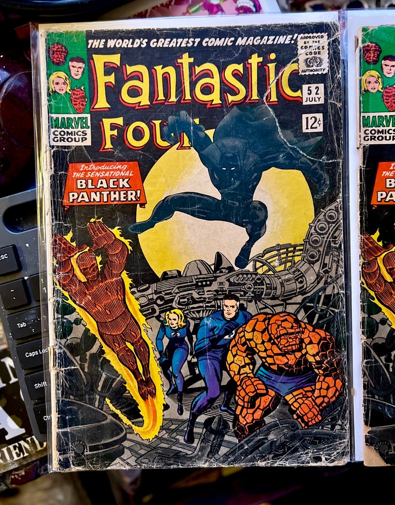 May include: A vintage comic book cover of Fantastic Four #52, featuring the Black Panther. The cover art includes the text "Introducing the Sensational Black Panther!" and the Marvel Comics Group logo. The comic is in a protective sleeve.