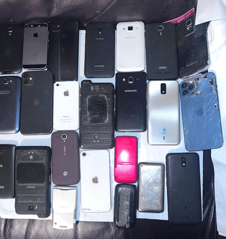 May include: A collection of various used smartphones, including models from Apple, Samsung, and Alcatel. The phones are in various conditions, with some showing signs of wear and tear. The image showcases a variety of colors and designs.