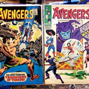 Puede incluir: Dos cómics vintage de Marvel con "The Avengers". El primer cómic, el número 39, muestra a un personaje musculoso en una pose heroica. El segundo cómic, el número 26, presenta al Capitán América y a la Avispa. Ambos cómics tienen colores vibrantes.