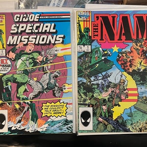 May include: Two comic book covers, one featuring G.I. Joe Special Missions #1 and the other featuring The Nam #1. Both covers feature action-packed scenes with soldiers and military vehicles.