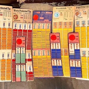 May include: A collection of vintage "Werts Protected Tip" tickets, featuring various colors and designs. The tickets have serial numbers, tip numbers, and text, with a prominent red circle on each. The tickets are arranged in vertical stacks.