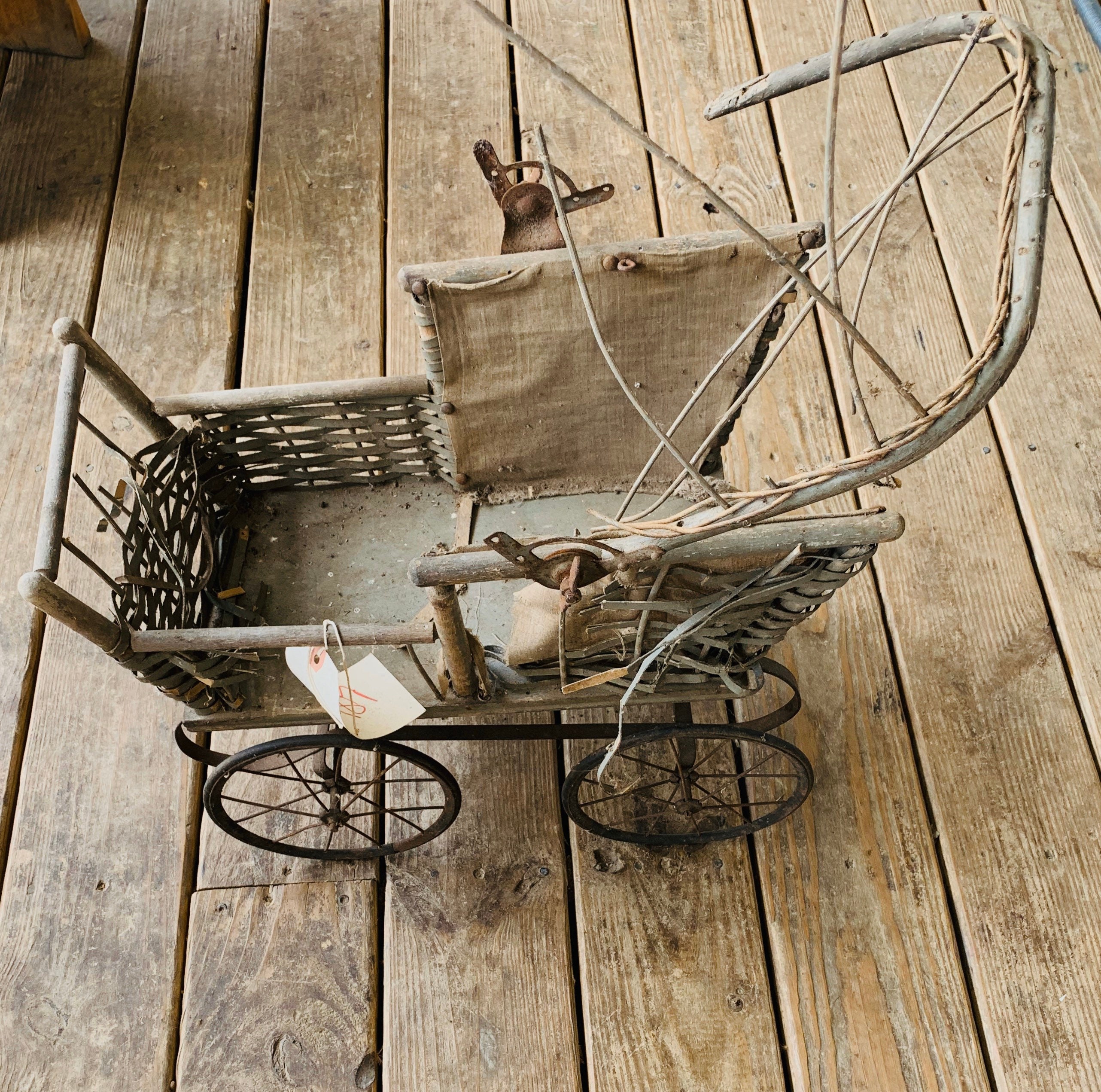 アンティークのベビードール用籐製ベビーカー。ヴィンテージ修復