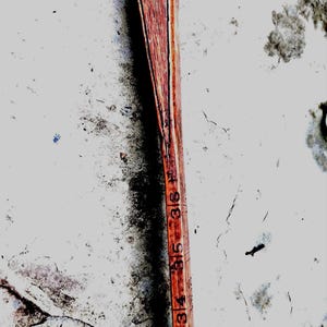 May include: A vintage wooden ruler with measurements in inches. The ruler is a warm reddish-brown color, with black markings indicating the inch increments. The numbers 32 through 36 are visible. The ruler appears aged and worn.