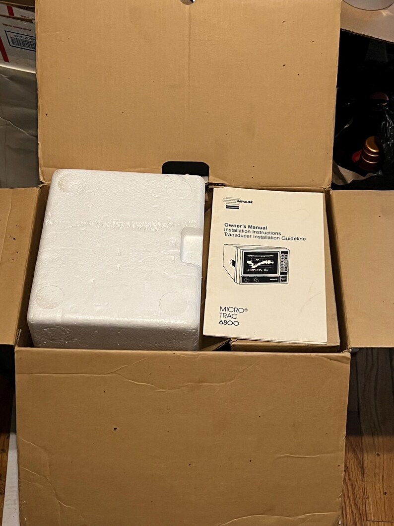 May include: A brown cardboard shipping box containing a white rectangular styrofoam block and a paper manual titled Owner's Manual Installation Instructions Transducer Installation Guideline MICRO TRAC 6800 with a line drawing of the device.