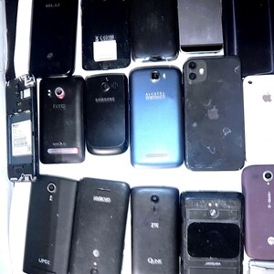 May include: A collection of various used smartphones, including brands like Apple, Samsung, and HTC. The phones are primarily black, with some blue and silver accents. Some phones have visible logos and model names.