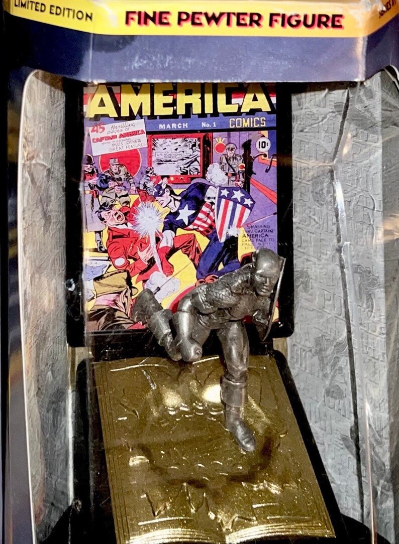 K&ouml;nnte beinhalten: Eine limitierte Feinzinnfigur von Captain America in Aktion. Die Figur wird vor dem Hintergrund eines Vintage-Covers von "America Comics" mit Captain America pr&auml;sentiert. Die Verpackung enth&auml;lt den Text "Limited Edition" und "Fine Pewter Figure".