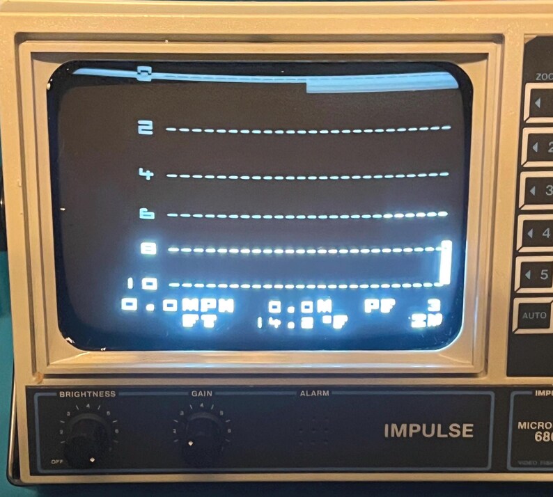May include: A beige Impulse 680 electronic device with a screen displaying a digital interface featuring horizontal dashed lines numbered 2, 4, 6, 8, and 10. The screen shows text including 0.0 MPH, 0.0M, PF 3, FT, and 14.8 F with control knobs below.