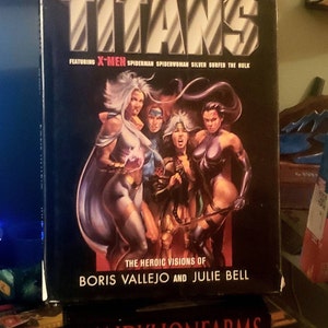 May include: A black and white comic book cover featuring the title "TITANS" with the words "FEATURING X-MEN SPIDERMAN SPIDERWOMAN SILVER SURFER THE HULK" and "THE HEROIC VISIONS OF BORIS VALLEJO AND JULIE BELL". The cover features a group of comic book characters, including Storm, Wolverine, and Jean Grey.
