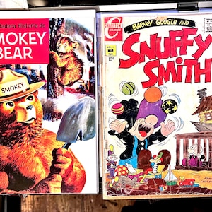 Puede incluir: Dos cómics vintage. Uno presenta a Smokey Bear con un sombrero de guardabosques con el texto "Smokey" y el título "La Verdadera Historia de Smokey Bear". El otro es un cómic de "Barney Google and Snuffy Smith".