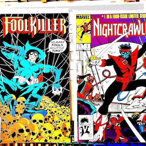 May include: Two vintage Marvel comic books. The first features "Foolkiller" in a blue costume, the second features "Nightcrawler" with a sword. Both comics have vibrant colors and bold text, typical of comic book art.