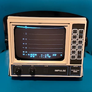 May include: An Impulse Micro-Trac 6800 monitor with a beige casing and a black control panel. The screen displays a digital interface with horizontal grid lines, numerical data, and text including MPH, FT, and 14.2 degrees Fahrenheit.