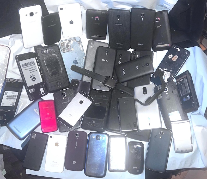 May include: A collection of various smartphones, including models from Samsung, Apple, and other brands. The phones are in various conditions, with some showing signs of wear and tear. The image includes a smartwatch.