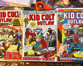 May include: Three vintage comic books featuring the character Kid Colt Outlaw. The covers are in color and feature illustrations of cowboys and gunfights. The titles of the comics are "Kid Colt Outlaw", "Kid Colt Outlaw", and "Kid Colt Outlaw".
