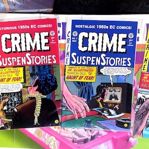 May include: A selection of vintage "Crime SuspenStories" comic books. The covers display striking text and colourful illustrations, with titles such as "Notorious" and "Bad." The comics are from the 1950s, with the text "Haunt of Fear" on the covers.