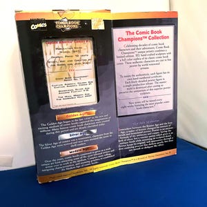 K&ouml;nnte beinhalten: Sammelbox f&uuml;r die Comic Book Champions-Kollektion mit Captain America Comics #1. Die Box enth&auml;lt Text und Grafiken, einschlie&szlig;lich des Ver&ouml;ffentlichungsdatums M&auml;rz 1941 und des Originalpreises von 10 Cent.