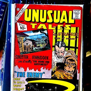 Puede incluir: Un cómic vintage titulado "UNUSUAL TALES" con una portada roja, amarilla y blanca. La portada presenta ilustraciones de una casa, un hombre y una criatura. El cómic está marcado "Still 10¢".