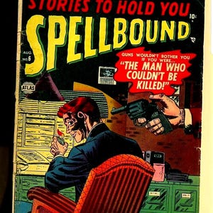 以下が含まれることがあります： 「Spellbound」のヴィンテージコミックの表紙。スーツ姿の男性がタバコに火をつけ、銃が彼を狙っている。表紙には「Stories to Hold You」と「The Man Who Couldn't Be Killed!」という太字のカラフルな文字が書かれている。コミックには「Aug. No. 6」と「毎月発売！」と書かれている。