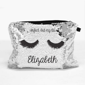 Könnte beinhalten: Silberne Glitzer-Kosmetiktasche mit schwarzen Wimpern und dem Text "perfect, but my lashes" und "Elizabeth".