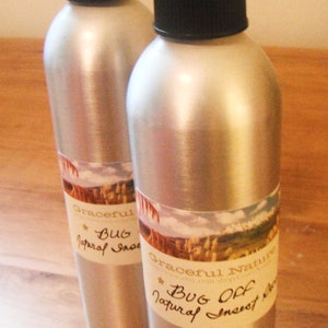 May include: Two silver spray bottles with black tops and labels that say "Graceful Nature Bug Off Natural Insect Repellent".