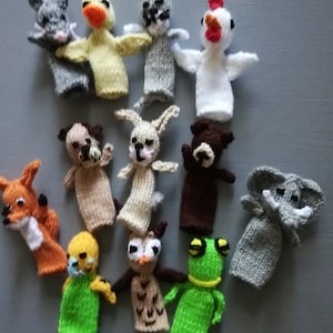 May include: A selection of twelve knitted finger puppets depicting different animals. The puppets include a mouse, duck, raccoon, chicken, dog, rabbit, bear, fox, bird, owl, frog, and elephant. Each puppet is crafted from yarn in a variety of colours.