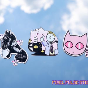 Pode incluir: Três autocolantes recortados com designs inspirados em anime. O autocolante da esquerda mostra uma figura a preto e branco com detalhes pontiagudos. O central representa uma personagem azul-clara com gravata e uma criatura cor-de-rosa.