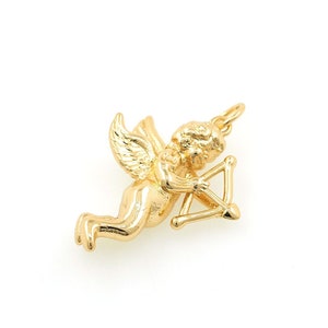 May include: Gold-toned charm of a cupid with wings, holding a bow and arrow.