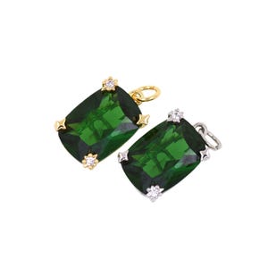 May include: Two gemstone pendants with emerald green rectangular stones. One pendant has a gold-colored bail and accents, the other has silver-colored accents. Both have small star-shaped accents and small clear stones.