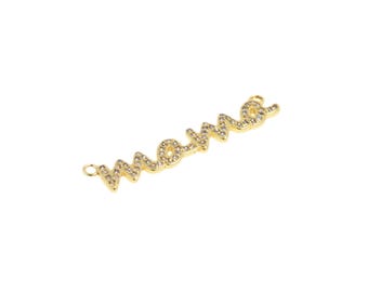 Puede incluir: Encanto dorado con la palabra "mama" escrita en letras cursivas. Las letras están incrustadas con diamantes de imitación transparentes.