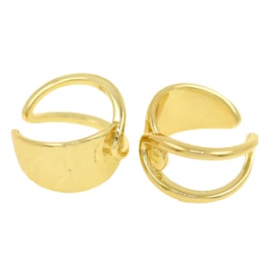 Puede incluir: Un par de pendientes de aro de oro con un diseño simple y moderno. Los pendientes están hechos de metal liso y pulido y tienen una forma ligeramente curvada.