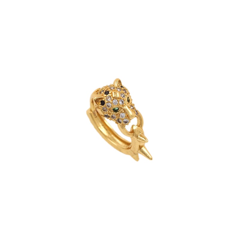 K&ouml;nnte beinhalten: Goldfarbener Ring mit einem detaillierten Pantherkopf-Design mit schwarzen und wei&szlig;en Strasssteinen und gr&uuml;nen Akzenten.