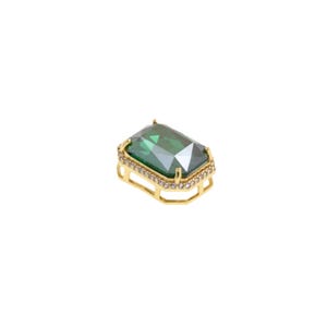 Puede incluir: Una gema rectangular de color dorado con una piedra central verde esmeralda facetada. La gema está rodeada por un halo de pequeños cristales transparentes y engastada en un marco de metal dorado. El diseño es elegante y llamativo.