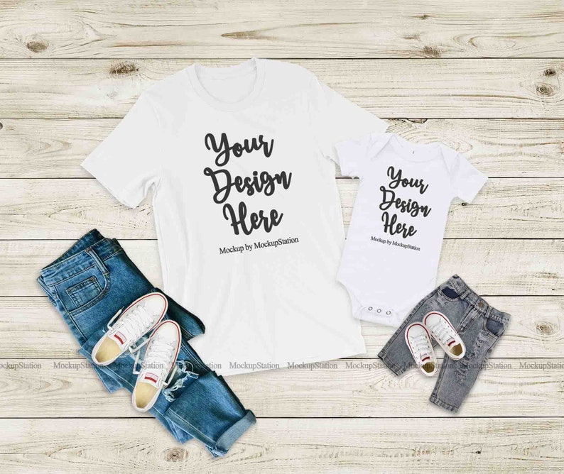 May include: Two white t-shirts, one adult-sized and one baby-sized, with the text "Your Design Here" on each. The shirts are laid out on a wooden surface with blue jeans and white trainers.