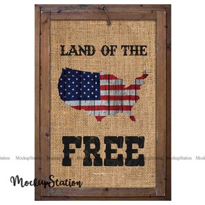 Pode incluir: Uma impress&atilde;o emoldurada em madeira r&uacute;stica com um fundo de juta. A impress&atilde;o apresenta uma bandeira americana vermelha, branca e azul em forma dos Estados Unidos. O texto "Land of the Free" est&aacute; impresso em preto abaixo da bandeira.