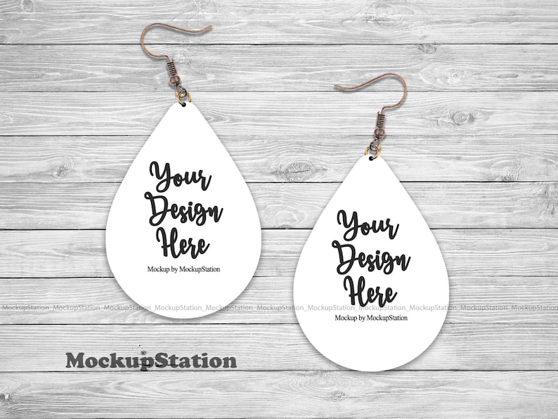K&ouml;nnte beinhalten: Ein Paar wei&szlig;e tropfenf&ouml;rmige Ohrringe mit einem silbernen Haken und dem Text "Your Design Here" auf jedem Ohrring. Mockup von MockupStation.