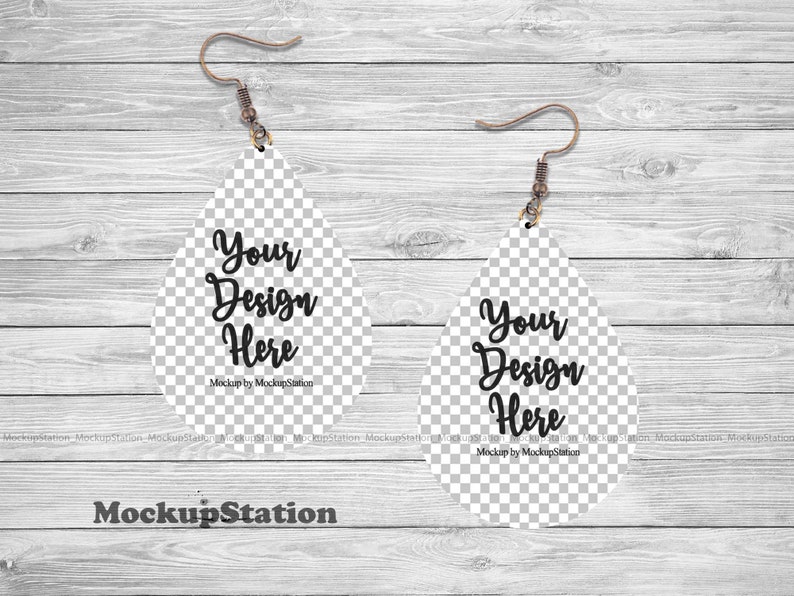 K&ouml;nnte beinhalten: Ein Mockup eines Paares tropfenf&ouml;rmiger Ohrringe mit transparentem Hintergrund. Die Ohrringe sind wei&szlig; und haben einen silbernen Haken. Der Text "Your Design Here" ist auf jedem Ohrring geschrieben. Der Text "Mockup by MockupStation" ist unter dem Text auf jedem Ohrring geschrieben.