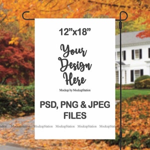 May include: A white 12" x 18" garden flag mockup with the text "Your Design Here" and "Mockup by MockupStation". The flag is displayed on a black metal pole in front of a house with a green lawn and autumn foliage.