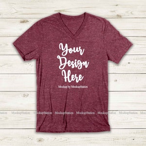 May include: A maroon v-neck t-shirt with a heather texture. The shirt has the text "Your Design Here" printed on the front in white.