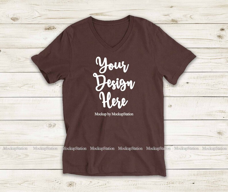 May include: A brown V-neck t-shirt with the text "Your Design Here" and "Mockup by MockupStation" printed on the front.