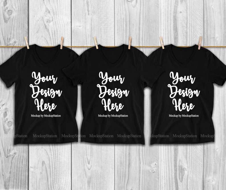 May include: Three black v-neck t-shirts hanging on a clothesline with the text "Your Design Here" and "Mockup by MockupStation" printed on each shirt.