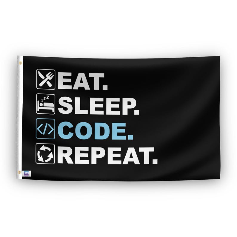 In a home setting, a flag with the saying "Eat Sleep Code Repeat" is mounted on a white wall by a side table.