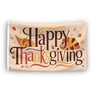 In a home setting, a flag with the saying "Happy Thanksgiving" is mounted on a white wall by a side table.