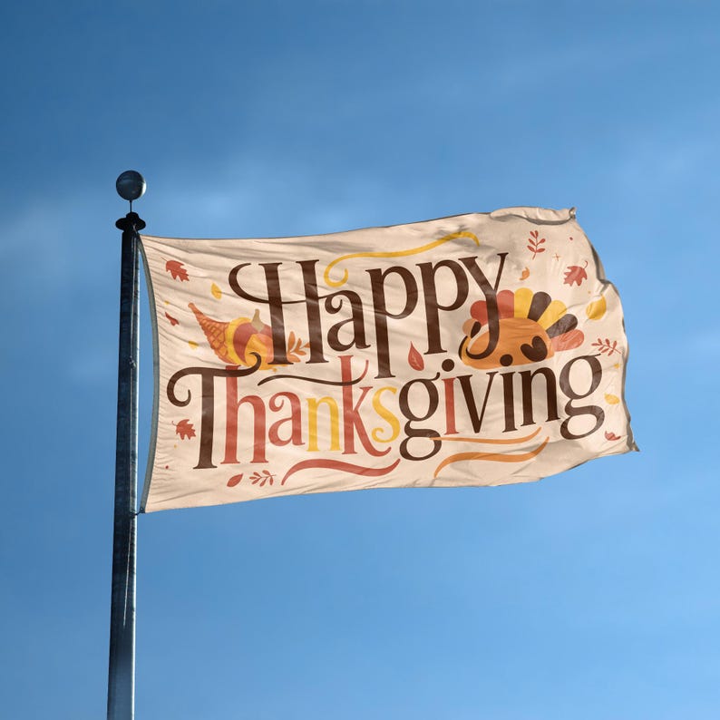 A flag with the saying "Happy Thanksgiving" displayed on a high pole, with a holiday themed color scheme.