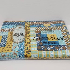 May include: A package containing a blue and yellow patchwork patterned bed sheet set. The package label reads "Crown Brand 90 x 108" and "Superior Quality Any Colourfast Guaranteed".