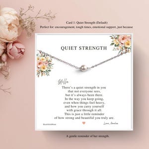 May include: A delicate silver necklace with a single pearl pendant is displayed on a white card. The card features the words "Quiet Strength" and a poem. Floral accents and a pink background complete the design.
