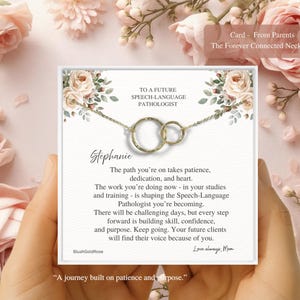 May include: A gold-colored necklace with two interlocking circles, presented on a card with floral accents. The card reads "To a Future Speech-Language Pathologist" and includes a personalized message. The background features pink roses.