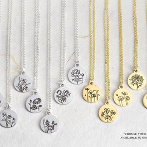May include: A collection of necklaces with round pendants, each featuring a different floral design. The necklaces are available in gold and silver finishes. The pendants are suspended from delicate chains, showcasing detailed botanical illustrations.