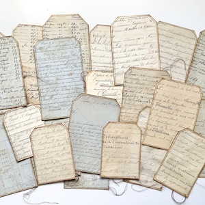 May include: A collection of vintage paper tags with handwritten text in French. The tags are various sizes and shapes, with some having frayed edges. The tags are on a white background.